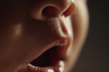 Close up view of a babys mouth opening in anticipation of soft food during mealtime moments