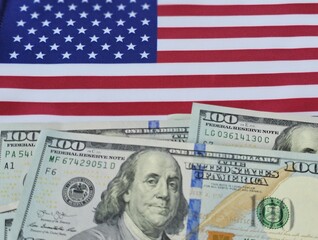 The American flag over stacks of dollar bills is a symbol of wealth and patriotism in the United...
