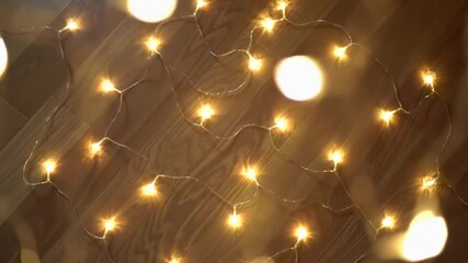 Warm fairy lights on wood floor, bokeh background, festive decor - Powered by Adobe