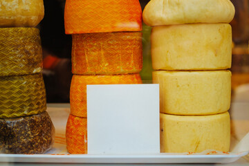 A set of different cheeses in a display case.
