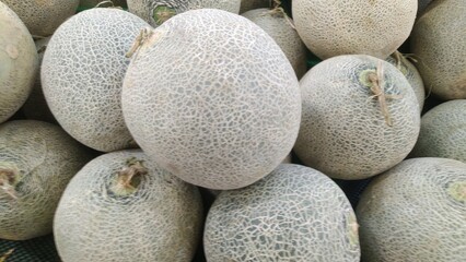 Fresh Whole Green Netted Melons Abundantly Displayed.perfect for healthy food and grocery marketing.
