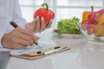 A female lab technician examines broccoli for scientific research in microbiology, biotechnology,...