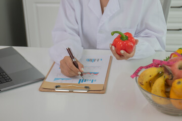 A female lab technician examines broccoli for scientific research in microbiology, biotechnology, and nutrition to advance health.