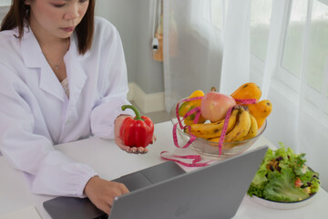 A female lab technician examines broccoli for scientific research in microbiology, biotechnology,...
