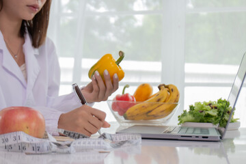 A female lab technician examines broccoli for scientific research in microbiology, biotechnology, and nutrition to advance health.