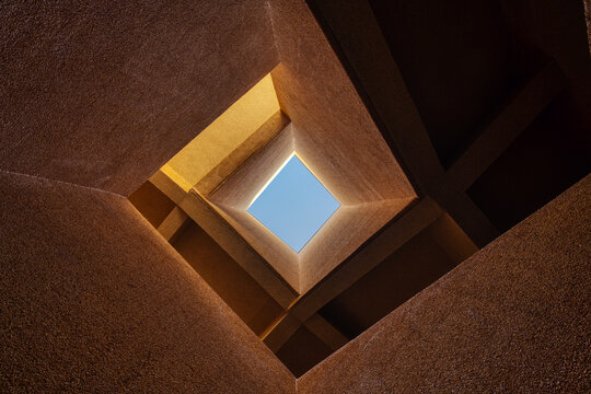 Modern Architecture Looking Up Through Geometric Building Structure to Blue Sky - Powered by Adobe