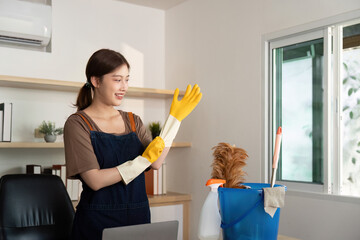 Home Cleaning. Smiling woman in yellow gloves ready to clean her workspace with a pet nearby.