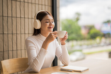 Young woman enjoying coffee and music in cafe