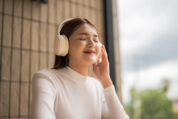 Young woman listening to music with headphones and relaxing