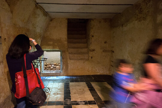 Tourist in the Crypt of the Capuchin Convent. Sassari. The remains of the friars were laid to rest in the basement of the church of San Francesco, originally built in the 16th century.