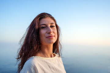 Portrait of a beautiful young woman enjoying freedom and looking serene in front of a beautiful...