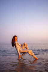 Woman professional seated on oceanic chair, embodying work life balance with serene sunset...