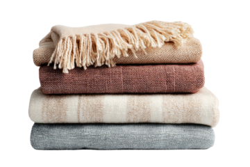 Stack of soft, textured blankets in muted tones.  Beige, rose, cream, and gray blankets layered.  Fringe detail on top blanket.  Studio shot, neutral background