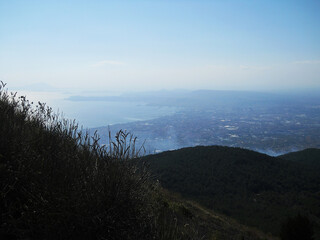 Stunning panoramic view from the summit of Mount Vesuvius overlooking the city of Naples, Italy. This cinematic stock footage captures the dramatic contrast between the rugged volcanic landscape and