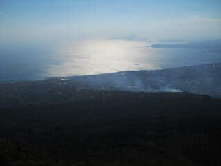 Stunning panoramic view from the summit of Mount Vesuvius overlooking the city of Naples, Italy. This cinematic stock footage captures the dramatic contrast between the rugged volcanic landscape and