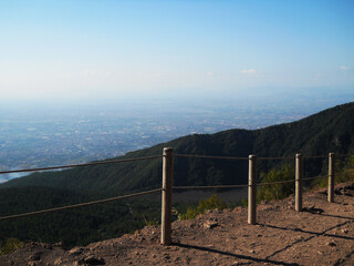 Stunning panoramic view from the summit of Mount Vesuvius overlooking the city of Naples, Italy. This cinematic stock footage captures the dramatic contrast between the rugged volcanic landscape and
