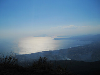 Stunning panoramic view from the summit of Mount Vesuvius overlooking the city of Naples, Italy. This cinematic stock footage captures the dramatic contrast between the rugged volcanic landscape and