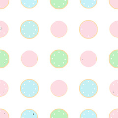 Assortment of round sugar cookies with pastel pink, blue, and green icing and white sprinkles.