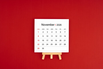 Calendar page for November 2026 with wood easel on a dark red background.