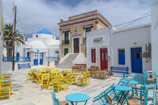Colourful cafe chairs below the blue dome of Agios Athanasios, Serifos