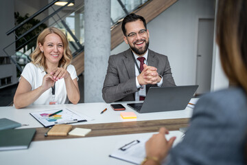 Smiling recruiters interviewing candidate for job position