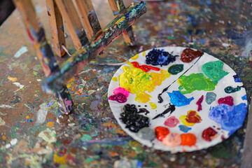 Art palette with colorful mixed paints  on smudges of paint wooden art table , concept art