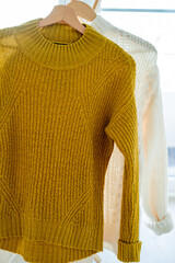 Warm autumn clothes knitted in the closet. Home organization.
