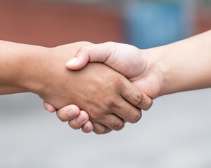 A close-up of two hands shaking, symbolizing agreement, partnership, and collaboration in a professional setting. Perfect for business-related themes.