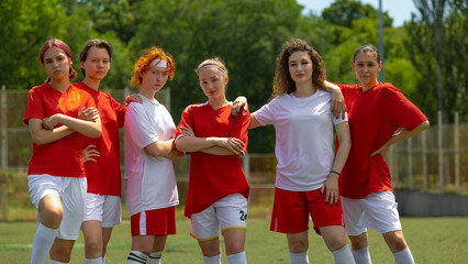 Confident women football team standing on field under bright sun. Concept of youth group identity in sport, casual post-game pose for club content, local football promotion.