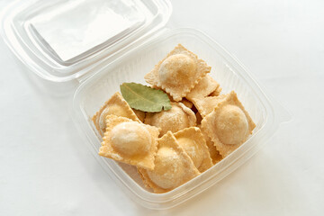 Freshly Made Ravioli with Bay Leaf in a Clear Container Perfect for Cooking and Serving Delicious Italian Pasta Dishes at Home or Special Occasions