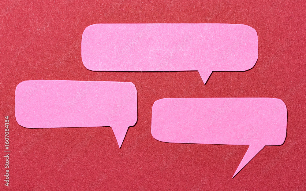 Fototapete pink cut out paper speech bubbles with copy space for text on red background, flat lay top view conc