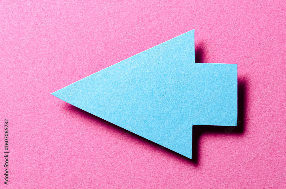 Fototapete blue cut out blank paper cardboard arrow direction sign with copy space for text on pink background,