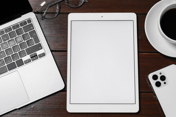 Tablet, laptop, smartphone, coffee and glasses on wooden table, flat lay