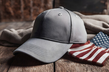 Gray baseball cap on rustic table with flag and tools