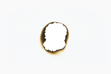 Round burnt paper hole with charred, scorched edges. A circular burn mark for spy themes, grunge effects, or creative designs, isolated on white background with clipping path.
