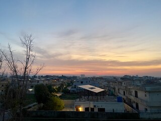 Soft evening tones fill the sky as city lights begin to flicker in this calm urban setting featuring eco-conscious solar energy infrastructure.