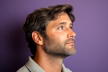 Fototapeta premium A graceful mature man with a modern hairstyle. Modish men's side part haircut - midlife white man with hair. Concept art of style for aging men. Purple solid background.