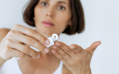 Woman Applying ointment from White Tube on Finger – Skincare, Treatment, Dermatology, Close-Up of Hands with Soft Focus Face in Background