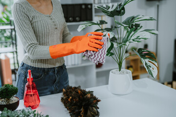 Office Cleaning Staff Sanitizing Conference Table. A dedicated cleaning professional in a blue...