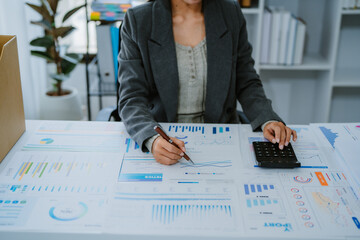 Asian businesswoman working on laptop analysis report chart in office.
