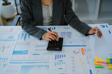 Asian businesswoman working on laptop analysis report chart in office.