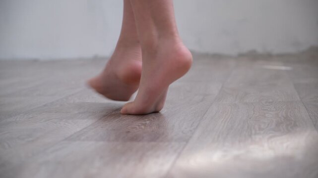 Barefoot teenage girl, dancer artist standing on tiptoe. Low section. Dance studio, tiptoe legs, position, practicing in ballet studio. Contemporary
