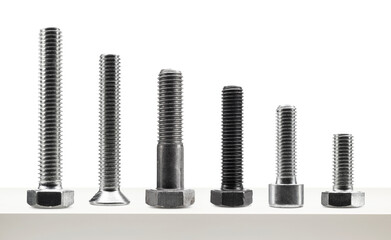 Variety of large steel screws on white table.