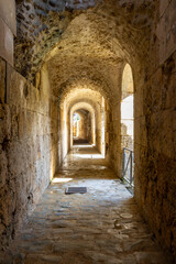 Interior of the catacombs at Itálica, Seville, Spain, showing ancient stone arches framing soft...