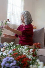 Elderly Woman Arranging Fresh Flowers at Home