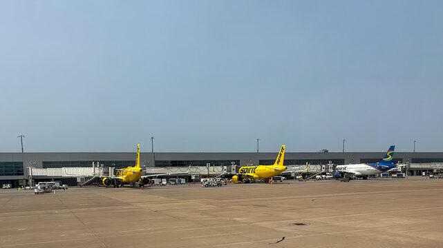 Three Spirit airplanes on the tarmac at Nashville International Airport (BNA) under a clear, blue sky