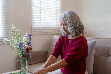 Elderly Woman Arranging Fresh Flowers at Home