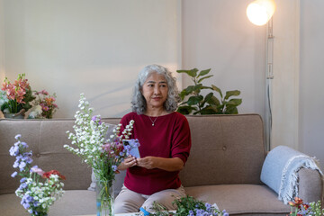 Senior Woman Taking Photo of Her Floral Arrangement