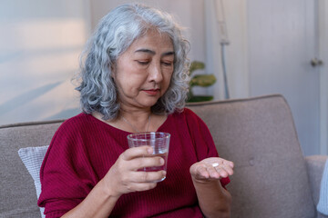 Senior Woman Taking Medication with Water at Home