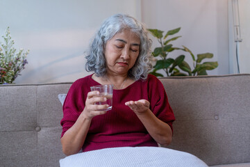 Senior Woman Taking Medication with Water at Home